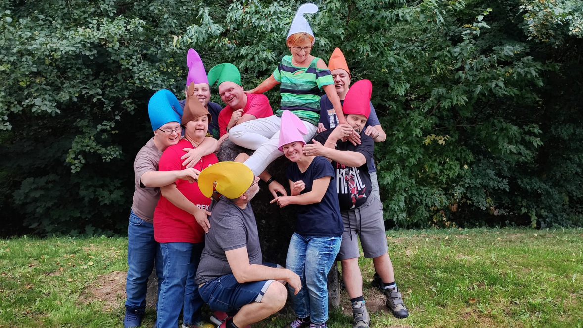 Eine Gruppe von Menschen steht zusammen. Alle haben Zipfelmützen auf.